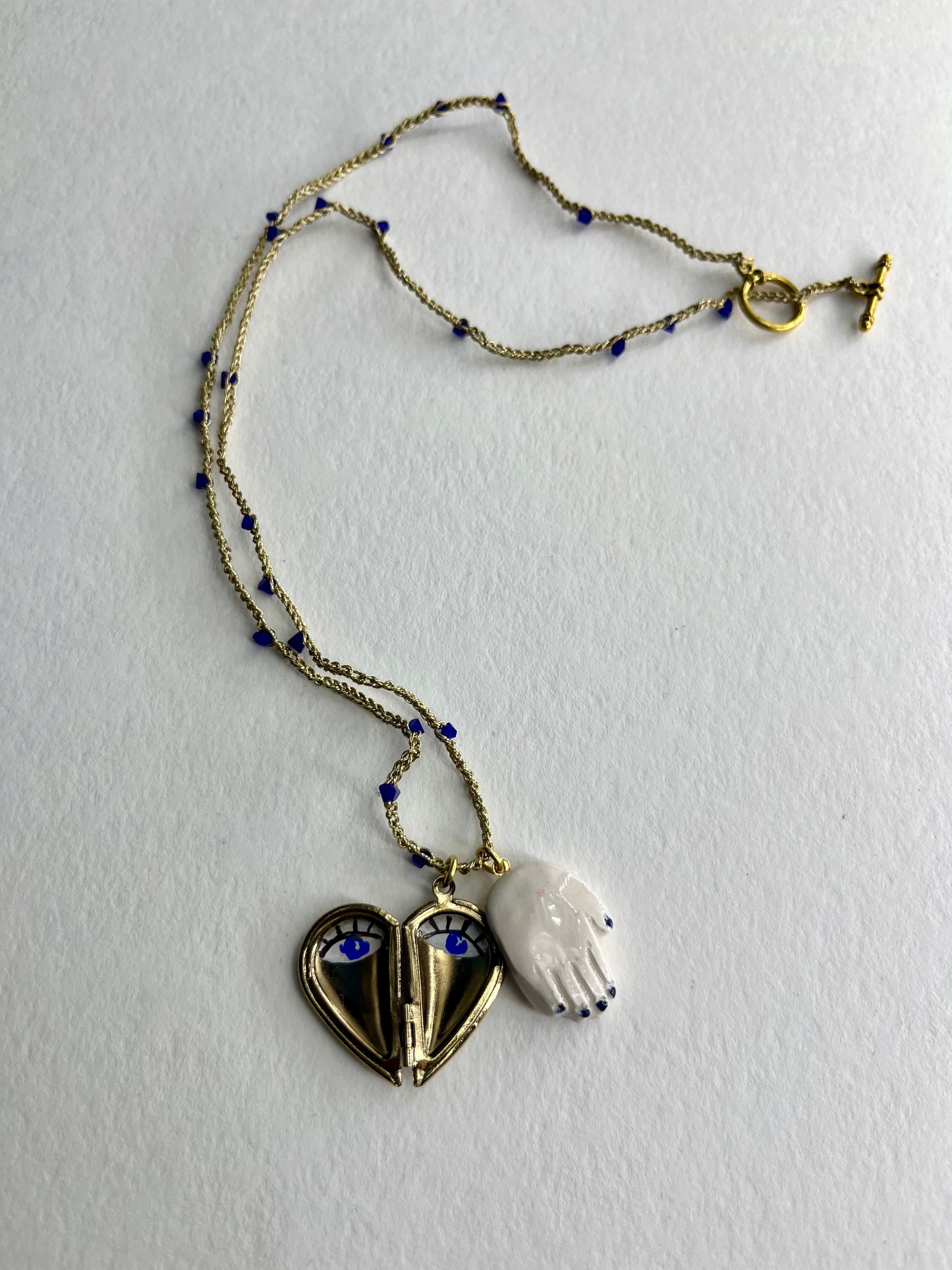 collana talisMANO con ciondolo lover's eye, mano in ceramica e metà cuore porta foto