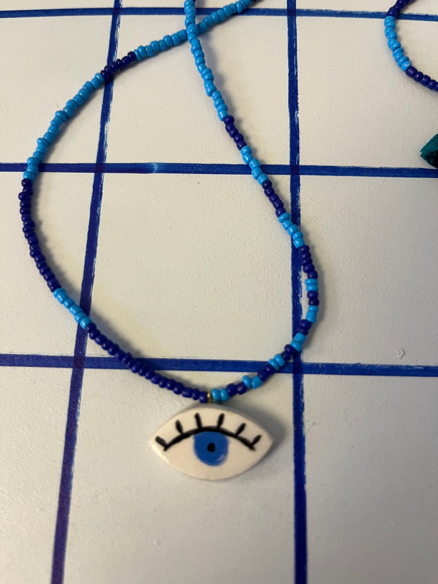 collana talisMANO con ciondolo a forma di occhio  e perline colorate