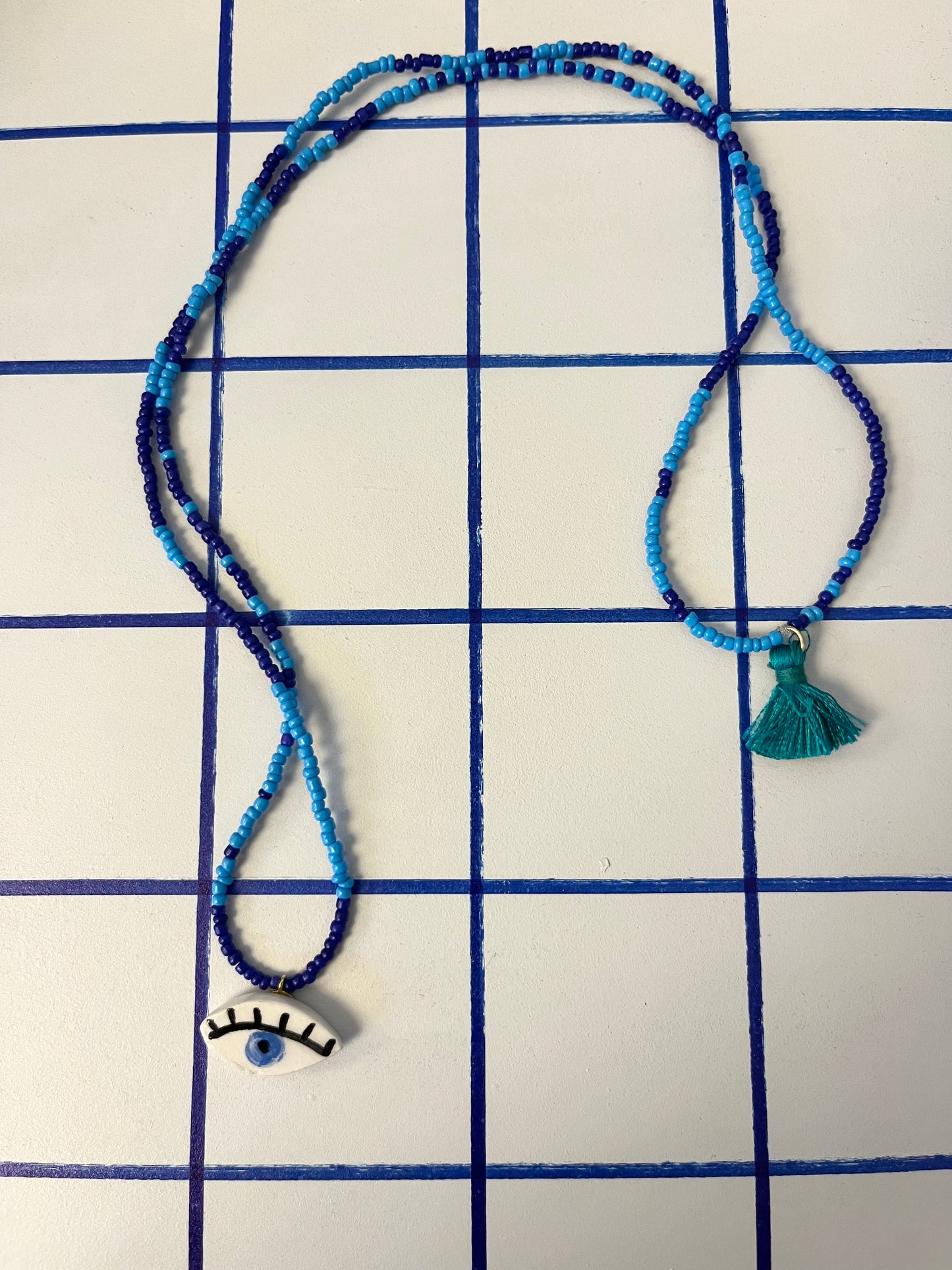 collana talisMANO con ciondolo a forma di occhio  e perline colorate