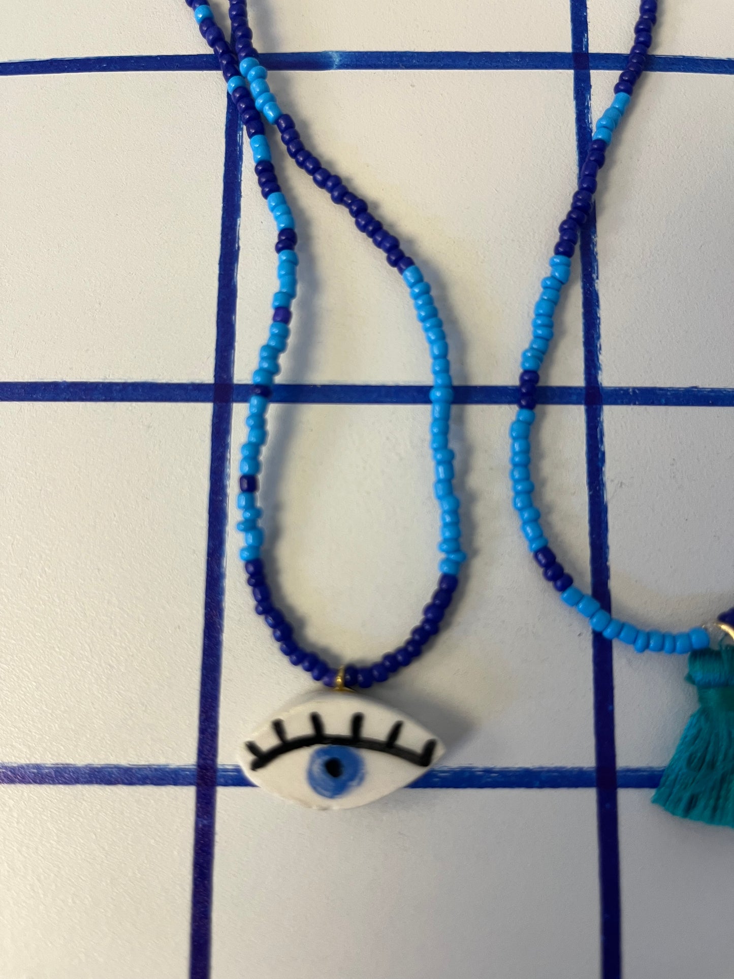 collana talisMANO con ciondolo a forma di occhio  e perline colorate