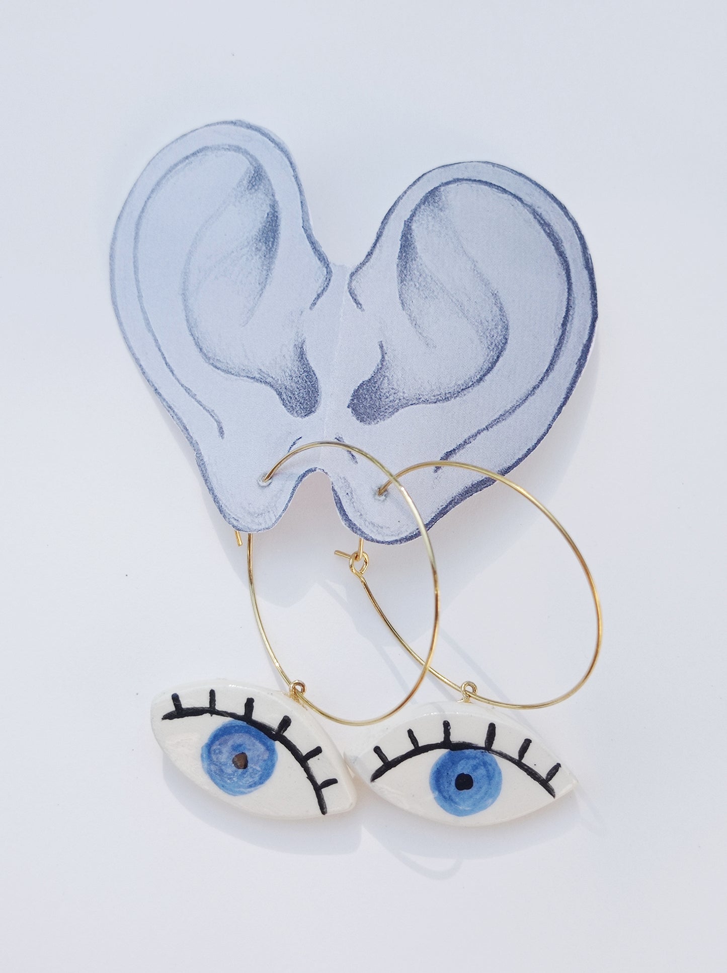 orecchini a cerchio dorati con  occhio in ceramica iride azzurro